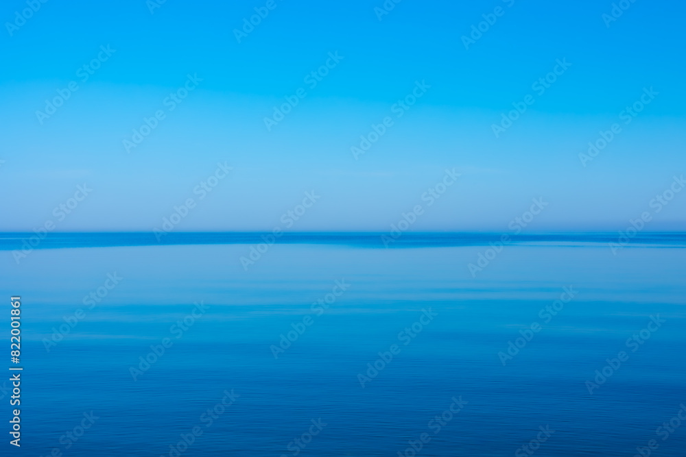 Fototapeta premium A very calm Baltic sea water surface with reflections of the sun. Beautiful summer scenery of Northern Europe.