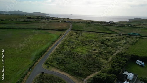 Drone on the green land of Calf of Man Island in Cregneash village showing houses, road and the sea photo