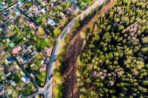Aerial view of a clearing on the outskirts of the forest, laying a gas pipeline in a dacha area photo