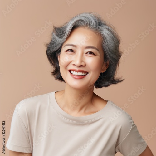 Beige Background Happy Asian Woman Portrait of Beautiful Older Mid Aged Mature Smiling Woman good mood Isolated Anti-aging Skin Care Face Beauty Product 