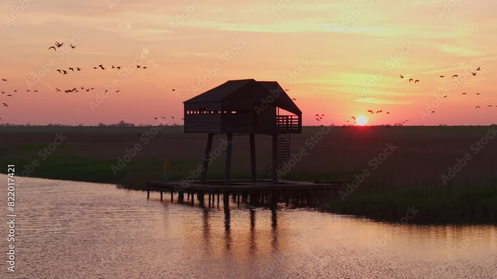 Aerial view of serene birdwatcher's hut at sunrise over Wadden Sea, Kiekkaaste, Netherlands. Aerial view of serene birdwatcher's hut at sunrise over Wadden Sea, Kiekkaaste, Netherlands.