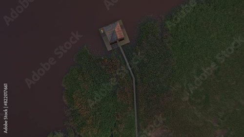 Aerial view of birdwatcher's hut, pathway, and water amidst greenery at Kiekkaaste, Groningen, Netherlands. photo