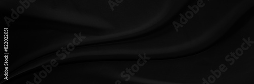 Black gray satin dark fabric texture luxurious shiny that is abstract silk cloth background with patterns soft waves blur beautiful. photo