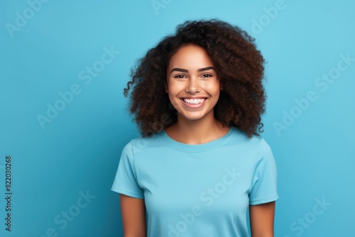 Blue background Happy black independant powerful Woman realistic person portrait of young beautiful Smiling girl Isolated on Background ethnic diversity equality acceptance concept with copyspace blan © Zickert