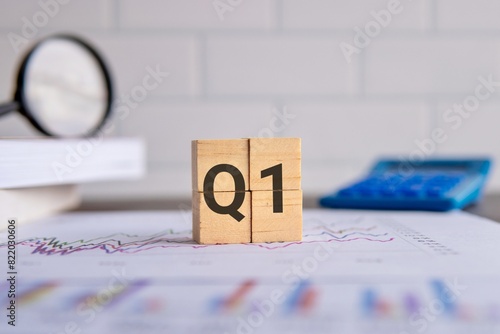 Close up image of wooden cubes with alphabet Q1 on office desk. First quarter concept. photo