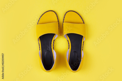 yellow female summer sandals on a yellow background top view