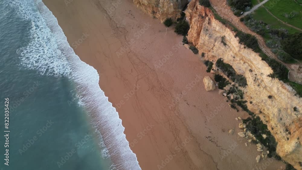 Aerial view of sandy beach and rocky cliffs by the clear blue ocean, Praia Nova, Porches, Algarve, Portugal. Aerial view of sandy beach and rocky cliffs by the clear blue ocean, Praia Nova, Porches, Algarve, Portugal.