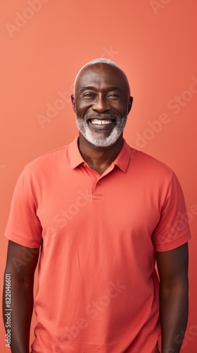 Coral Background Happy black american independant powerful man. Portrait of older mid aged person beautiful Smiling boy Isolated on Background ethnic