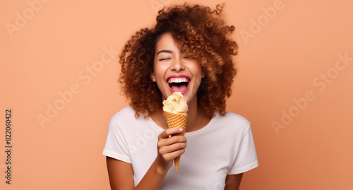 Summer portrait of happy cheerful smiling young woman eating ice cream cone on studio background