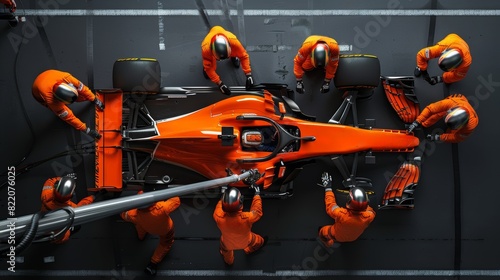 High-angle view captures crew in orange suits working swiftly on race car. team's actions precision and coordination essential for successful pit stop.