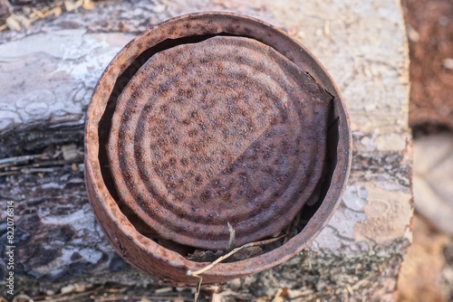 one brown round rusty iron tin can lies on the gray table on the street