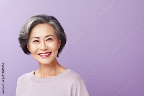 Lavender Background Happy Asian Woman Portrait of Beautiful Older Mid Aged Mature Smiling Woman good mood Isolated Anti-aging Skin Care Face Beauty Product Banner with copyspace  © Zickert
