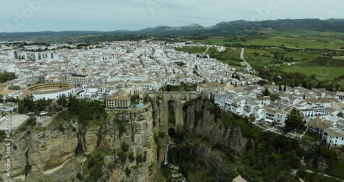 Aerial view of historic town Ronda with whitewashed buildings, terracotta roofs, and scenic mountains, Andalusia, Spain.