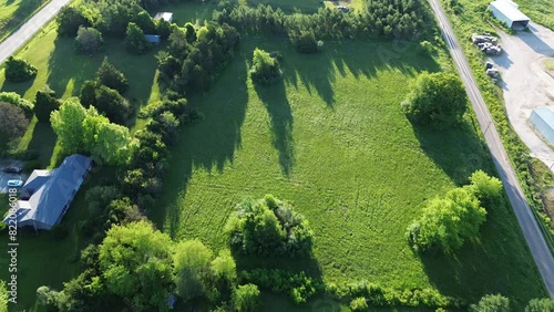Flyover large farmhouses and ranches along rural US-60 BUS highway and service road in Mountain Grove Missouri, countryside acreage lots, lush greenery trees grass meadows in peaceful Midwest