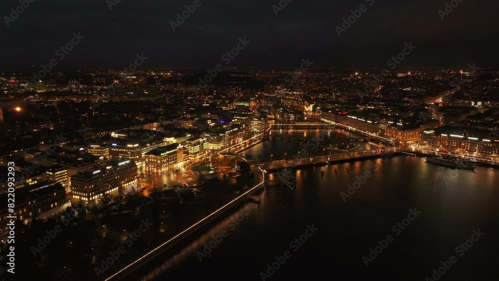 Aerial view of vibrant lights of Geneva in Switzerland, showing illuminated buildings and reflections in Rhone River. Dense urban environment highlights the nightlife around Mont Blanc bridge Aerial view of vibrant lights of Geneva in Switzerland, showing illuminated buildings and reflections in Rhone River. Dense urban environment highlights the nightlife around Mont Blanc bridge