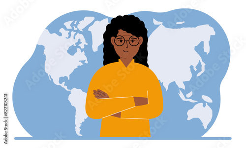 A woman stands in front of a world map with his arms crossed.