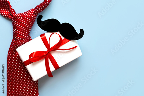Happy Father's Day. Top view of necktie, mustache and gift box with copy space for text