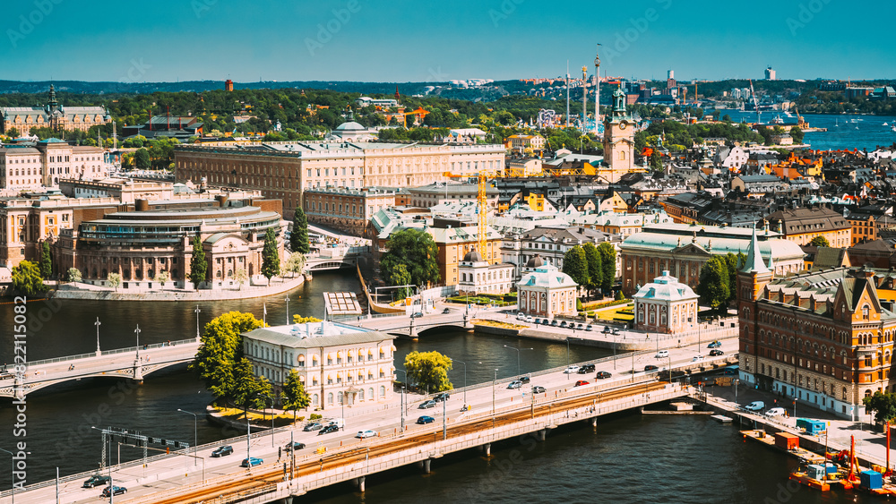 Fototapeta premium The aerial perspective shows a city with a river and a bridge, capturing a blend of urban and natural elements like water, buildings, and sky
