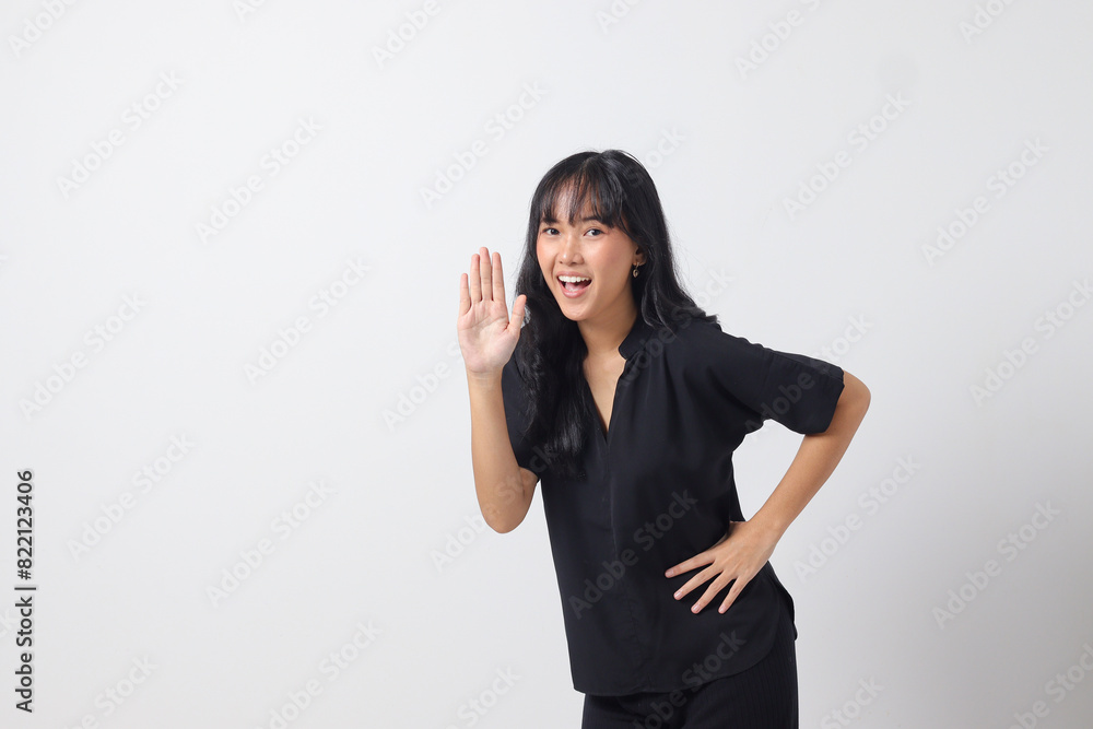 Portrait of attractive Asian woman in casual shirt raising hand, greeting and saying hi. Businesswoman concept. Isolated image on white background Portrait of attractive Asian woman in casual shirt raising hand, greeting and saying hi. Businesswoman concept. Isolated image on white background