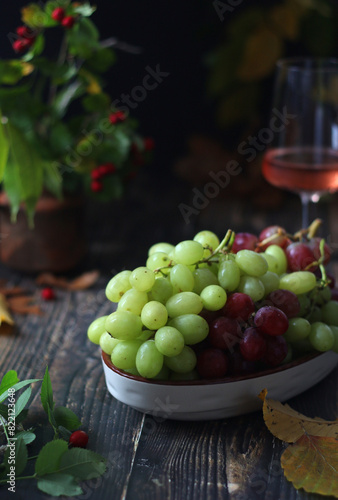 A bowl with red and green grape in rustic style