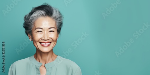Teal Background Happy Asian Woman Portrait of Beautiful Older Mid Aged Mature Smiling Woman good mood Isolated Anti-aging Skin Care Face Beauty Product Banner with copyspace 