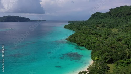Drone video of green shore near turquoise sea under blue clouds. Tropical paradise. Sanma, Vanuatu.