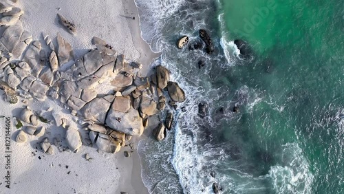 Aerial view of rocky beach with turquoise water and luxury homes, Cape Town, South Africa.