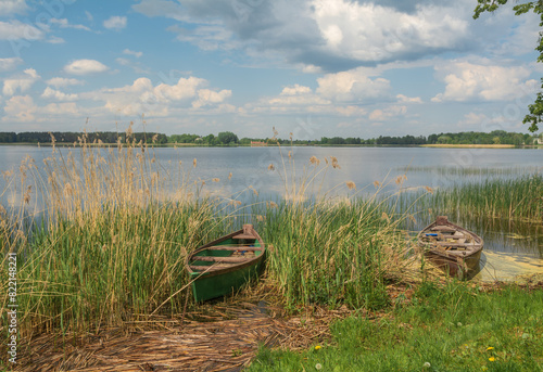 two old wooden boats on the shore of the lake.