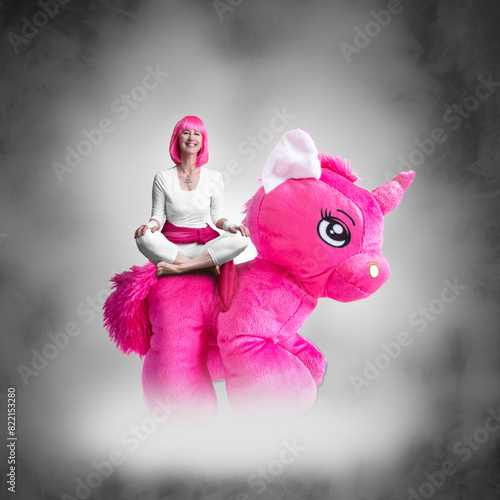 Portrait of a young woman with pink hair and a pink stuffed unicorn