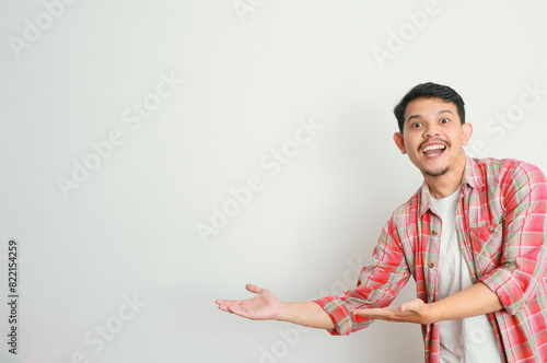 an asian man smiles and points to something with his hand photo