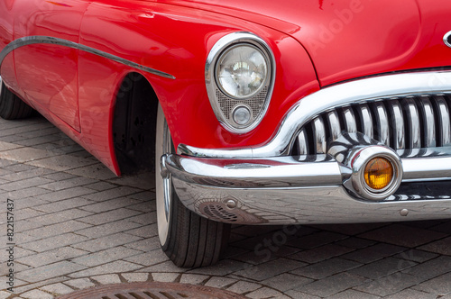 Red retro car. Front part, bumper, headlight.