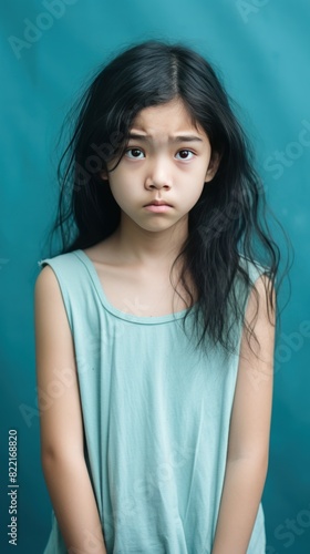 Aqua background sad Asian child Portrait of young beautiful in a bad mood child Isolated on Background, depression anxiety fear burn out health issue problem mental overstrained overwhelmed concept © Zickert