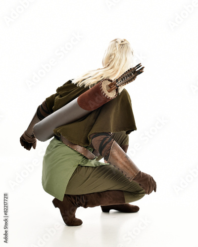 Bild auf Leinwand full length portrait of blonde female model wearing green fantasy elf warrior halloween costume with leather armour