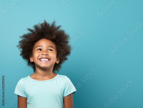 Blue background Happy black american african child Portrait of young beautiful kid Isolated on Background ethnic diversity equality acceptance concept with copyspace 