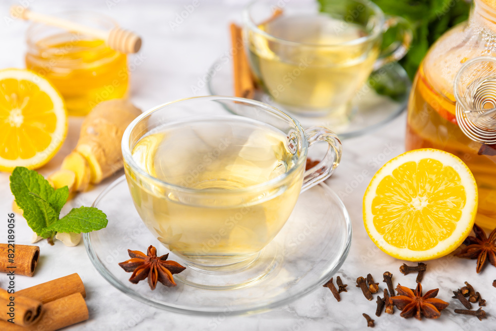 Fragrant hot tea with cinnamon stick and anise on a textured wooden background. A cup of hot tea with honey, lemon, mint and apples. Spicy tea with spices. Immunity tea. Health concept.Copy space. Fragrant hot tea with cinnamon stick and anise on a textured wooden background. A cup of hot tea with honey, lemon, mint and apples. Spicy tea with spices. Immunity tea. Health concept.Copy space.