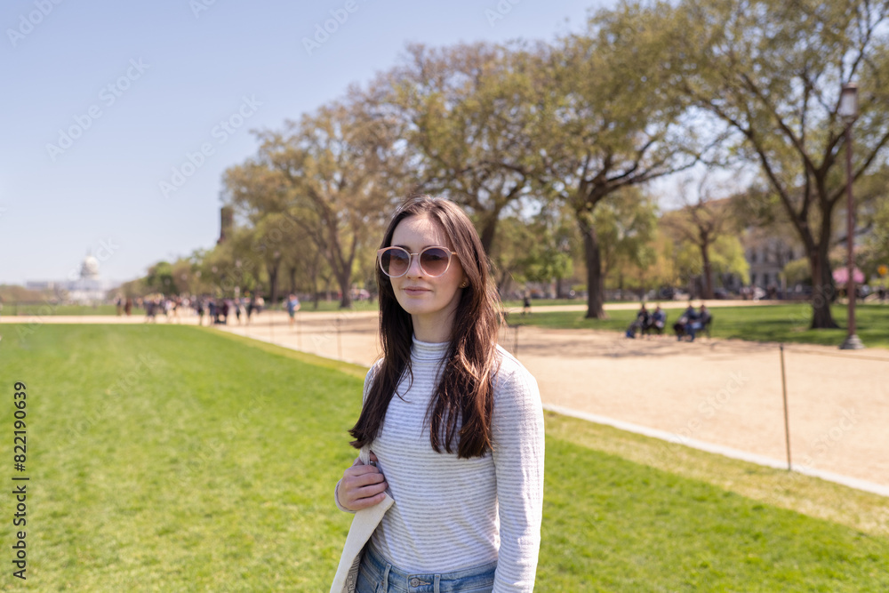 A young woman standing on the mall in Washington DC with the Capitol building in the background A young woman standing on the mall in Washington DC with the Capitol building in the background