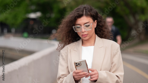 Beautiful business woman portrait in summer in the city with a phone in her hands