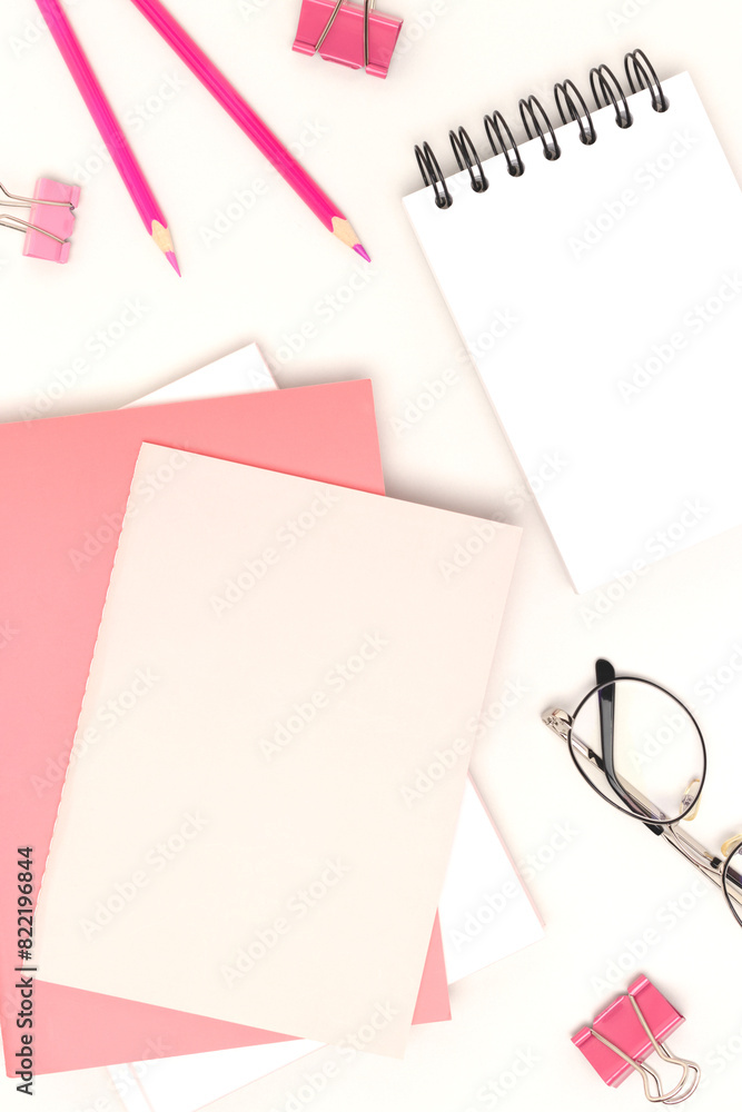 Pink colored school supplies on a gray background. Blank notepad. Pink colored school supplies on a gray background. Blank notepad.