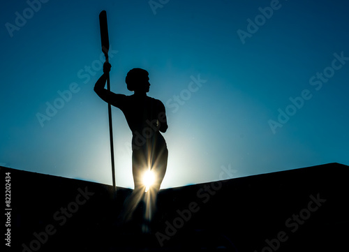 Silhouette of a statue of an athlete against the sky. photo