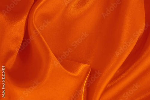 Orange fabric cloth texture for background and design art work, beautiful crumpled pattern of silk or linen.