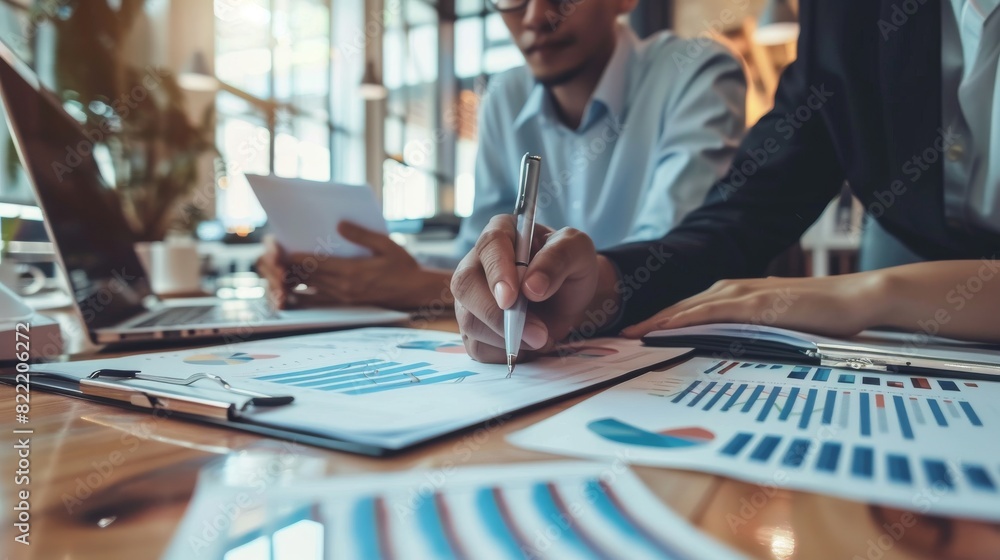 A corporate team is focused on discussing financial reports, charts, and graphs in a collaborative work environment A corporate team is focused on discussing financial reports, charts, and graphs in a collaborative work environment
