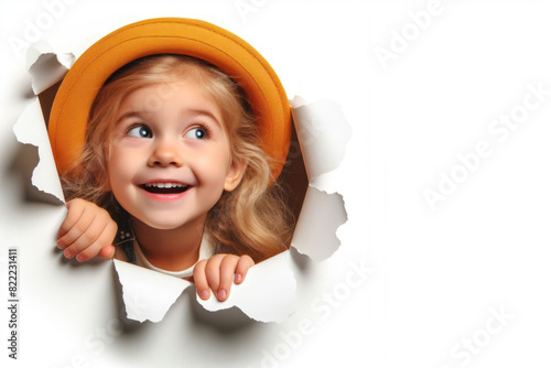 funny kid girl peeking out of hole in paper wall Isolated on white background