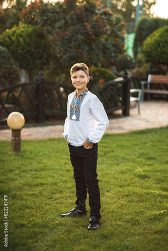 Obraz na płótnie Young teenager in an embroidered shirt posing in a summer park w salonie