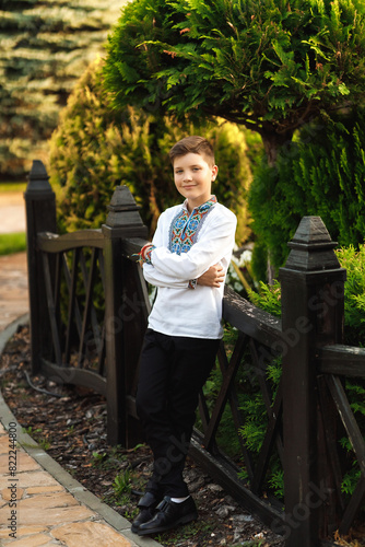 Obraz na płótnie Young teenager in an embroidered shirt posing in a summer park w salonie