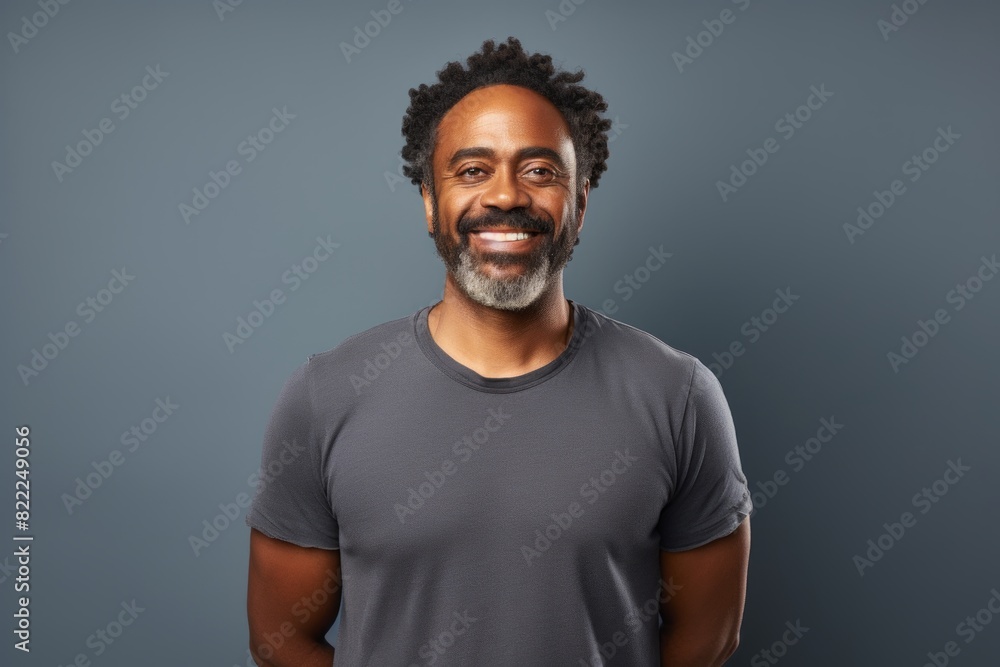 Obraz premium Portrait of a joyful afro-american man in his 40s smiling at the camera on blank studio backdrop