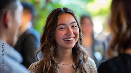 networking at alumni reception or post-graduation event, with laughter, conversation, sense of camaraderie. Spirit of community, connection captured as graduates reflect on shared experiences