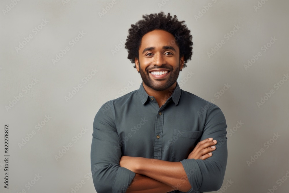 Obraz premium Portrait of a joyful afro-american man in his 30s with arms crossed on light wood minimalistic setup