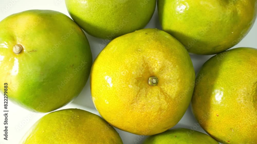 Clusters of Citrus sinensis, green oranges, boast a vibrant glossiness, speckled with hints of yellow, signaling ripeness and diverse nutrients. Orange fruit background.
Clusters of Citrus sinensis, green oranges, boast a vibrant glossiness, speckled with hints of yellow, signaling ripeness and diverse nutrients. Orange fruit background.
