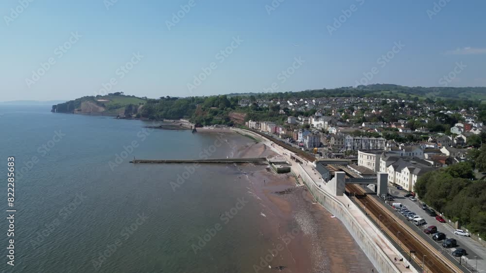Dawlish, South Devon, England: DRONE VIEWS: The coastline at Dawlish featuring the railway track and station, the beach, sea, houses and town quay. Dawlish is a popular UK holiday resort (Clip 5). Dawlish, South Devon, England: DRONE VIEWS: The coastline at Dawlish featuring the railway track and station, the beach, sea, houses and town quay. Dawlish is a popular UK holiday resort (Clip 5).