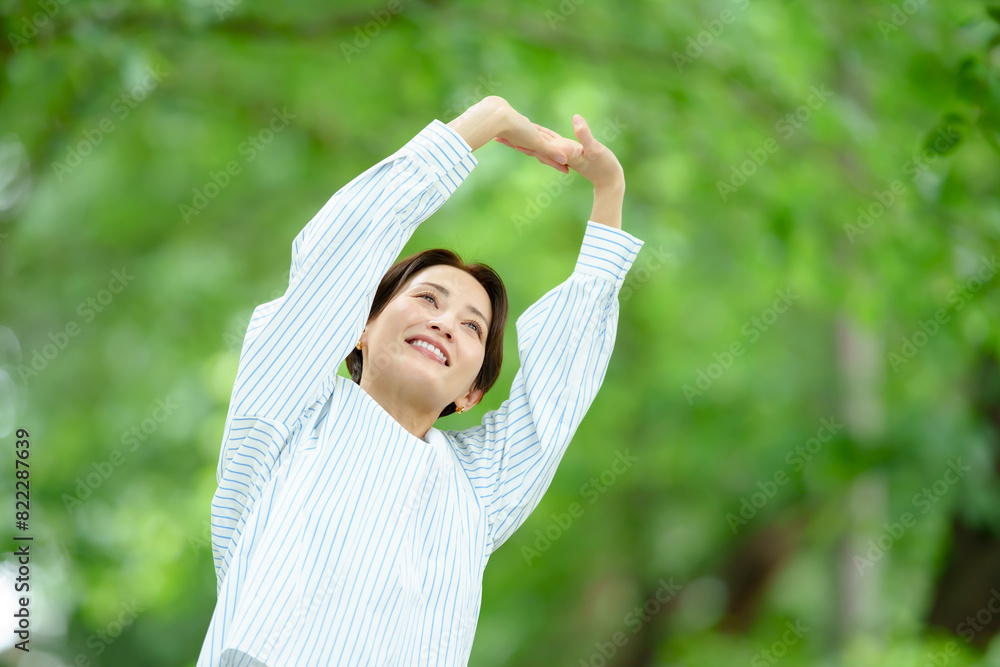 新緑の中でストレッチする女性 新緑の中でストレッチする女性